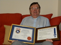 Canon Goddard with his two awards.